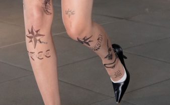 Donna cammina indossando tacchi neri e collant effetto tattoo