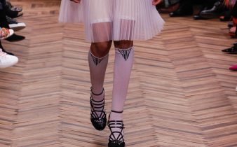 Modella sfila per Prada con calze gambaletto invernali bianche